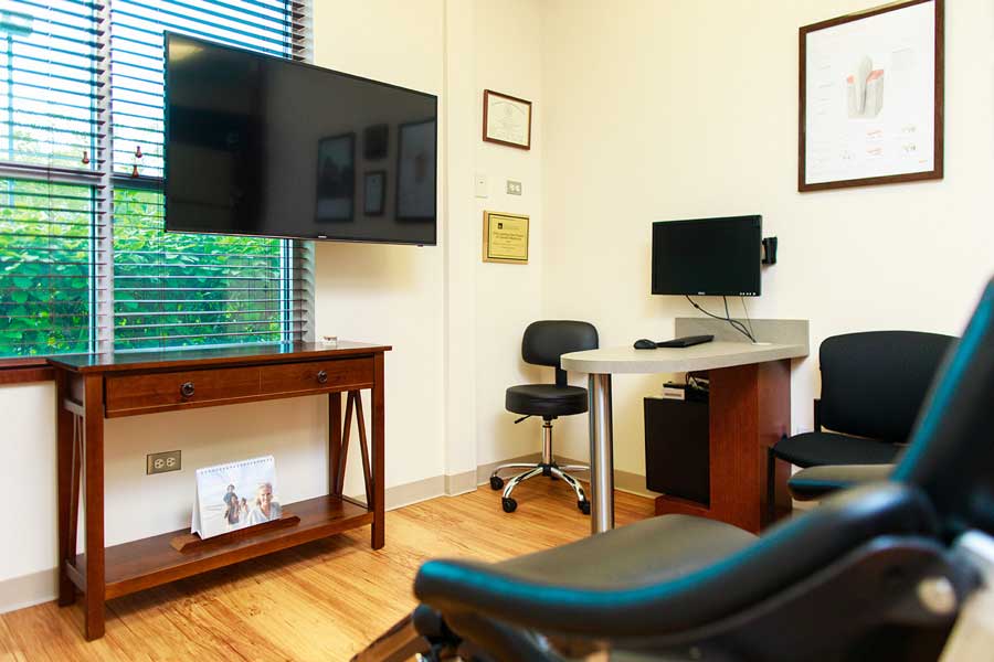 Office room with chairs and TV at Wheaton Oral Surgery in Naperville, IL