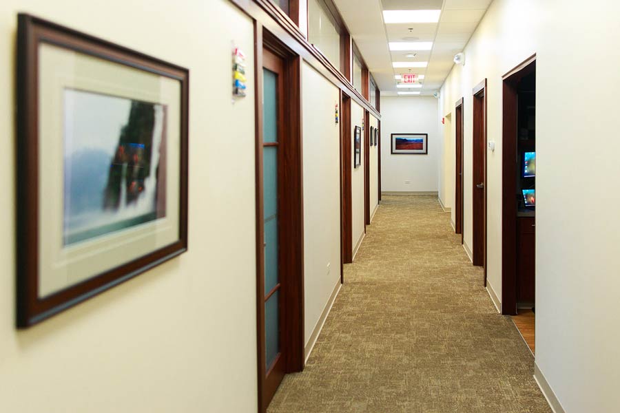 Hallways with framed photos on walls at Wheaton Oral Surgery in Naperville, IL