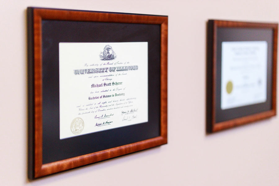Dr. Scherer framed degrees on wall at Wheaton Oral Surgery in Naperville, IL