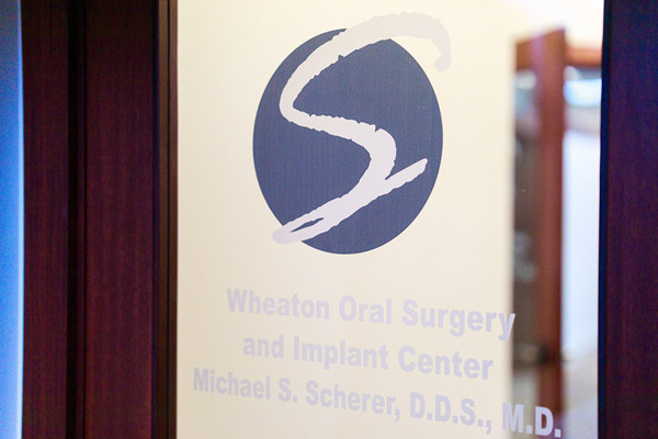 Office logo sign on glass door at Wheaton Oral Surgery in Naperville, IL