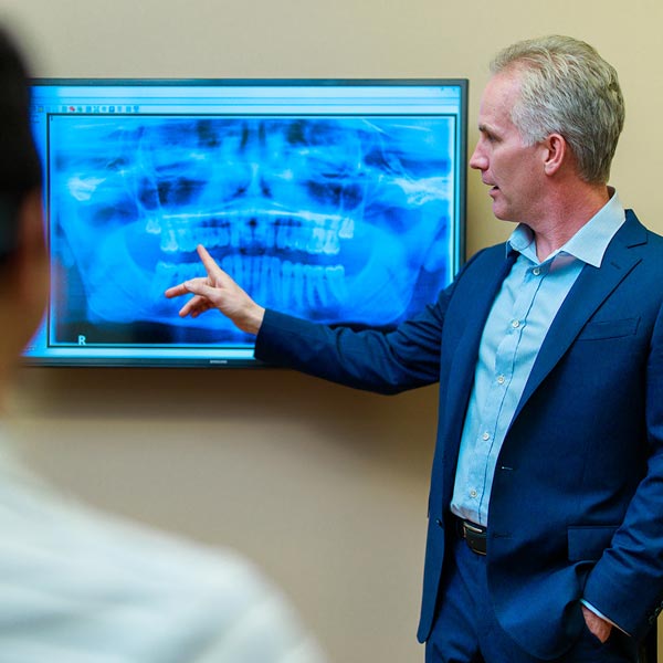 Dr. Scherer pointing to digital x-ray at Wheaton Oral Surgery in Naperville, IL 