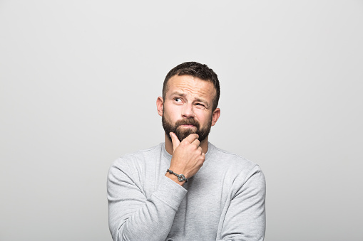 Male client making a questioning face and gesture at Wheaton Oral Surgery in Naperville, IL